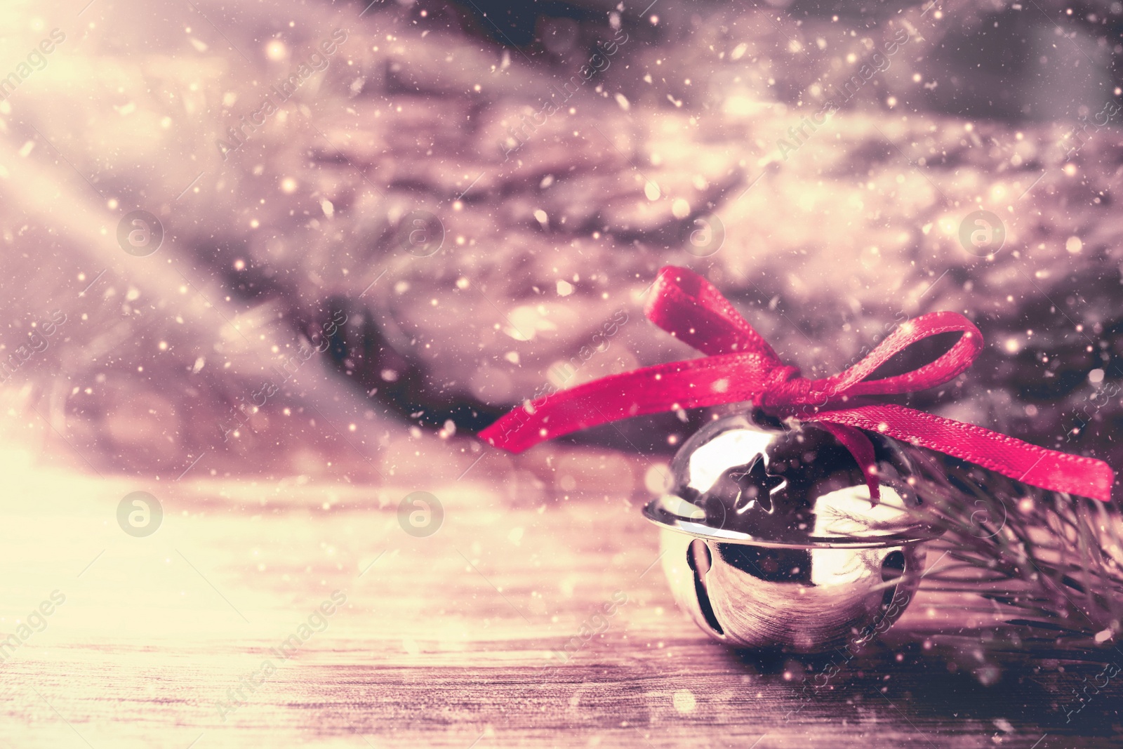 Image of Shiny silver sleigh bell on wooden table. Space for text