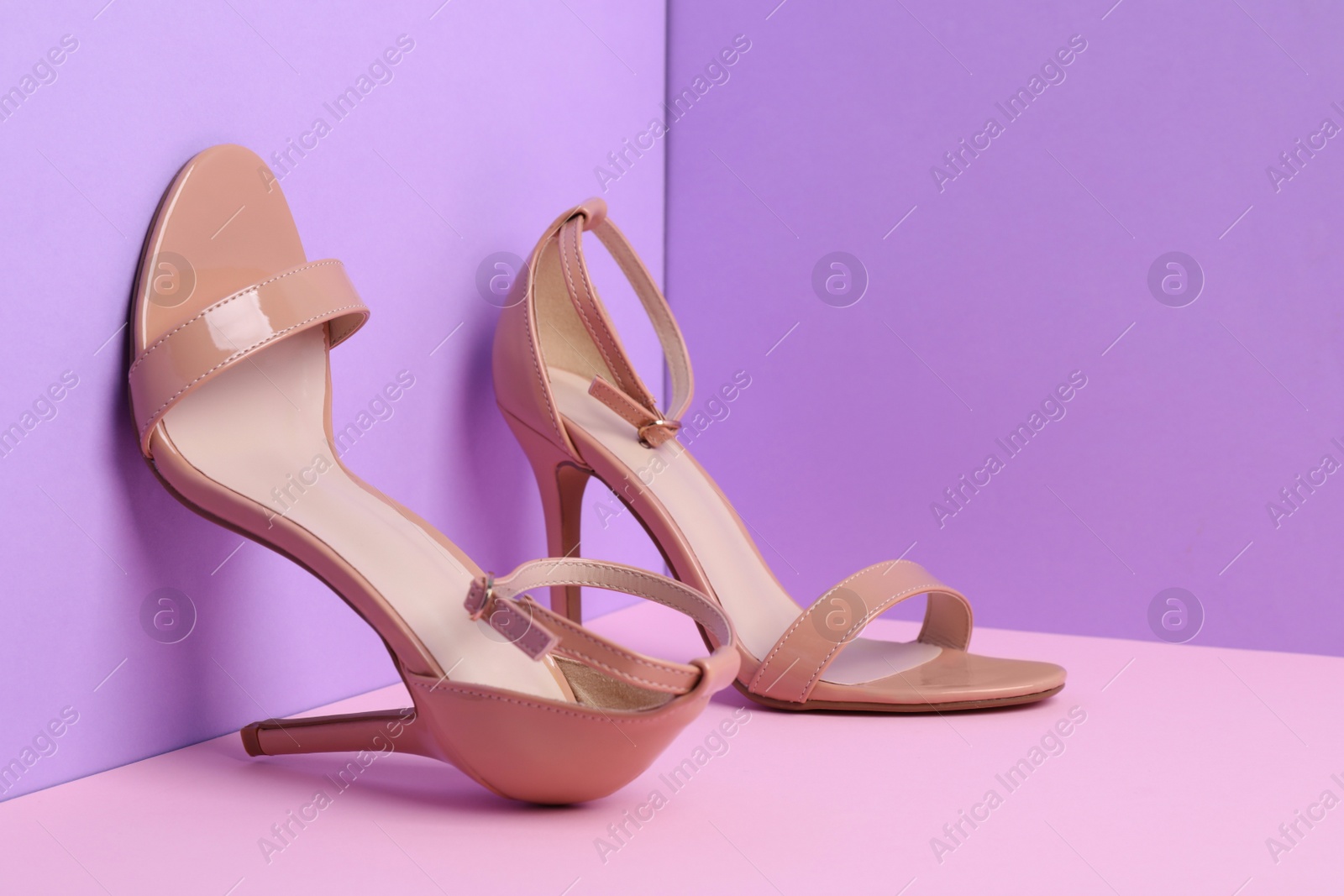 Photo of Pair of stylish high heeled shoes on color background