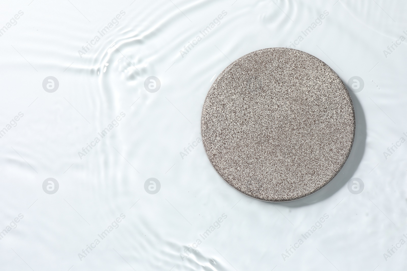 Photo of Presentation of product. Stone podium in water on white background, top view. Space for text