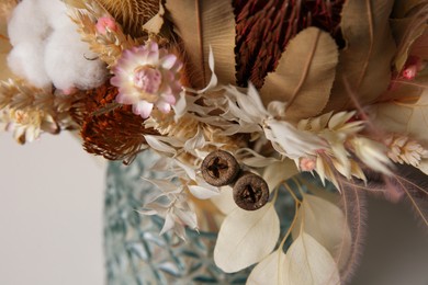 Photo of Beautiful dried flower bouquet in glass vase, closeup