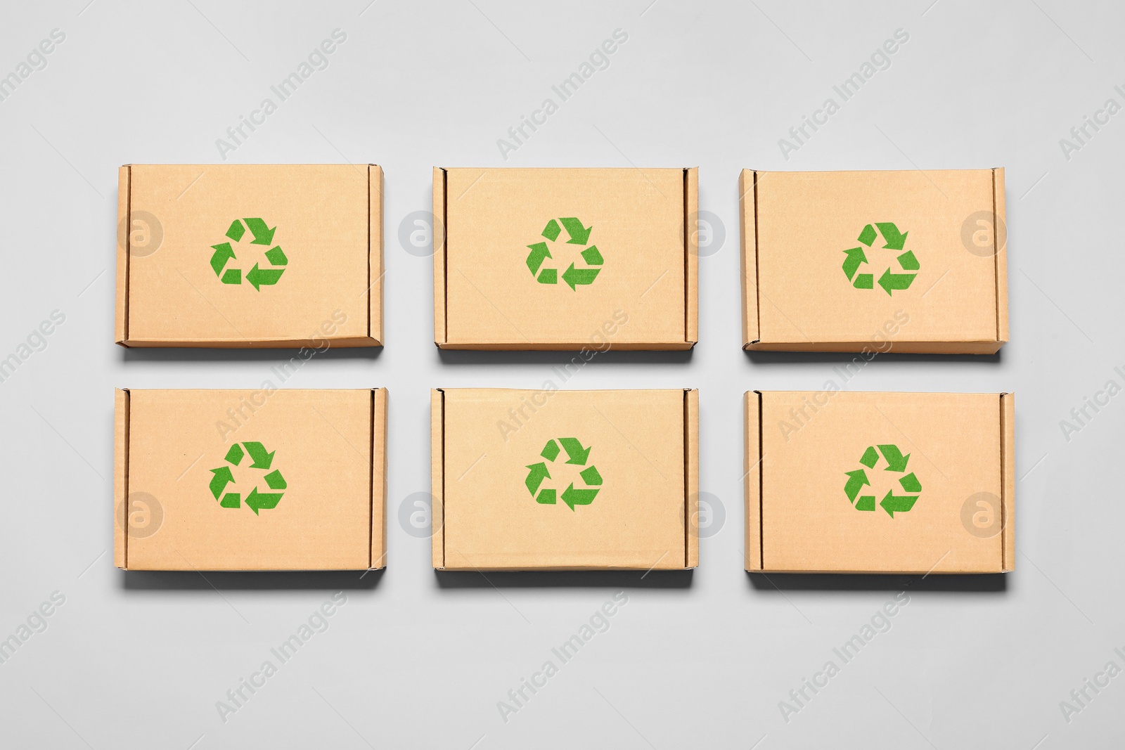 Image of Cardboard boxes with recycle sign stamps on light grey background, flat lay