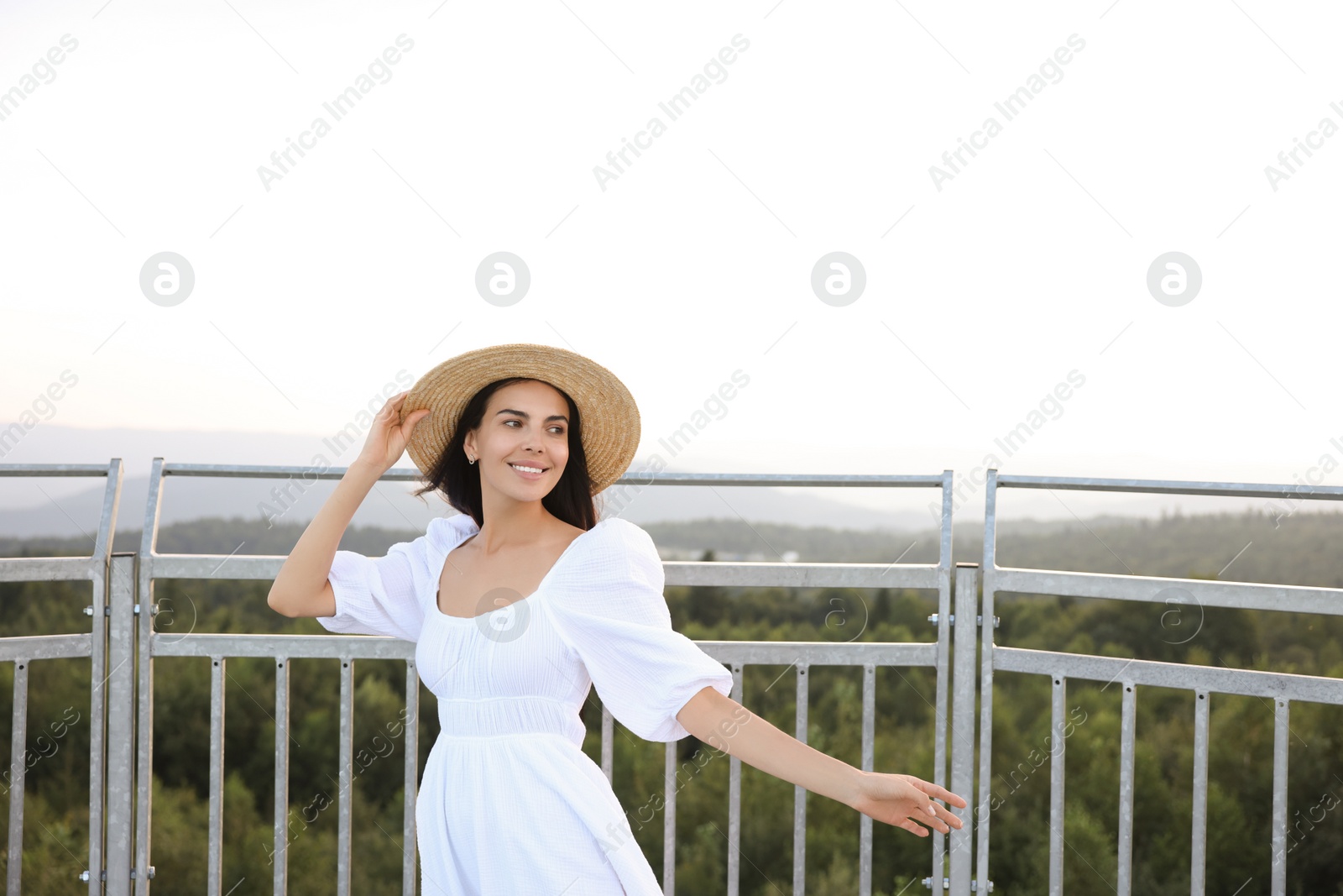 Photo of Feeling freedom. Happy woman enjoying nature near metal railing outdoors