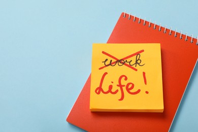 Photo of Notebook, sticky notes on light blue background with space for text, above view. Life and work balance concept