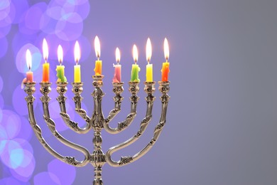 Hanukkah celebration. Menorah with burning candles on grey background with blurred lights, space for text