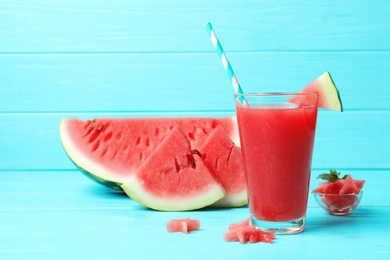 Photo of Summer watermelon drink in glass and sliced fruit on table