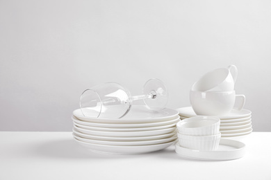 Photo of Set of clean dishes on white table