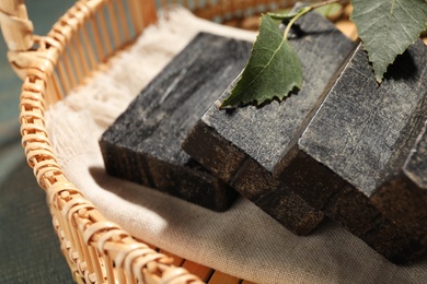 Photo of Natural tar soap in wicker basket, closeup