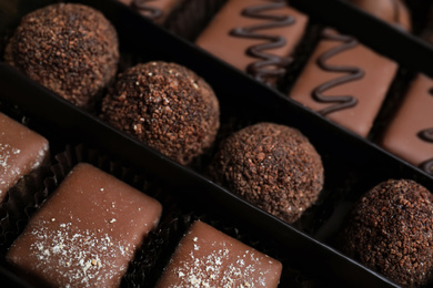 Different delicious chocolate candies in box, closeup