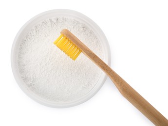 Bowl of tooth powder and brush on white background, top view