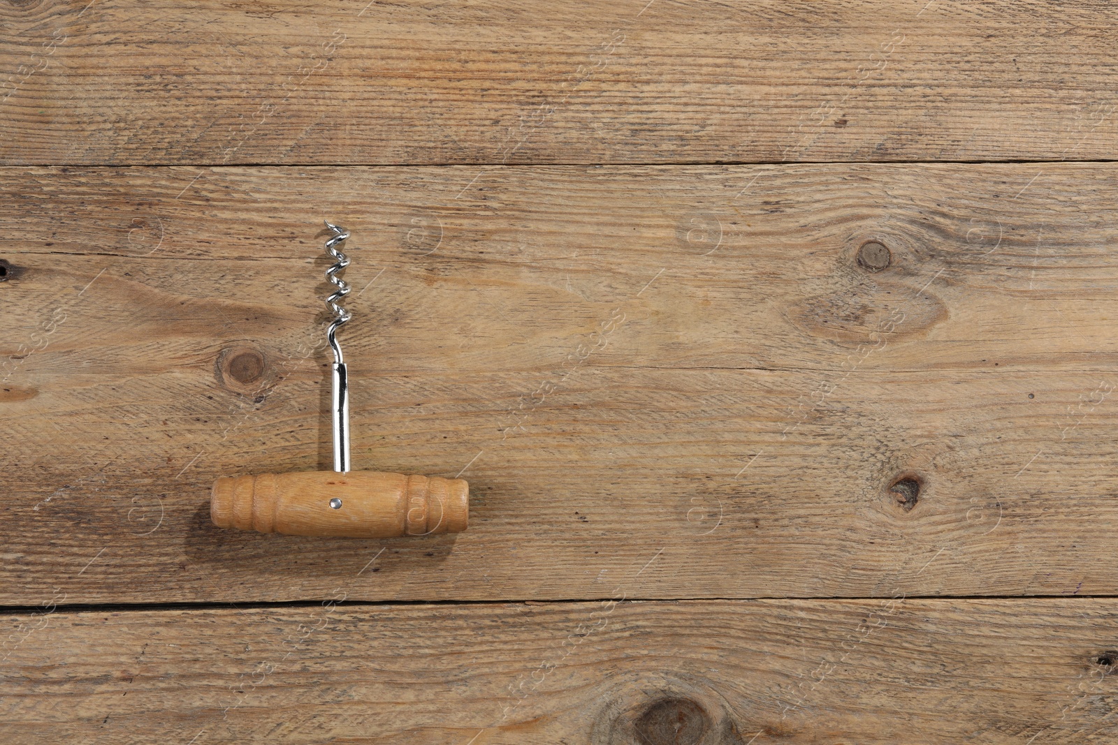 Photo of One corkscrew on wooden table, top view. Space for text