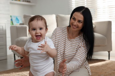 Happy mother with her cute baby at home