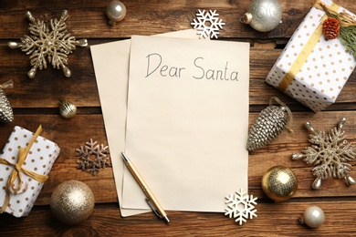 Flat lay composition with letter saying Dear Santa on wooden table, space for text