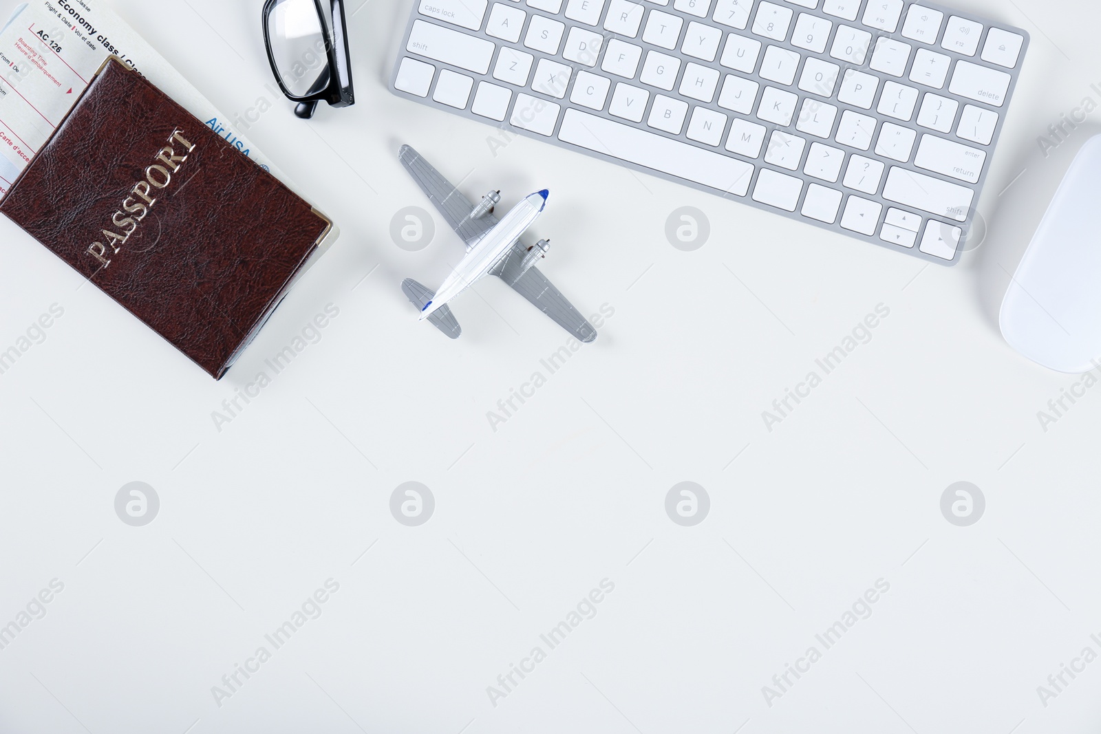 Photo of Flat lay composition with airplane model and computer keyboard on light background. Travel agency concept