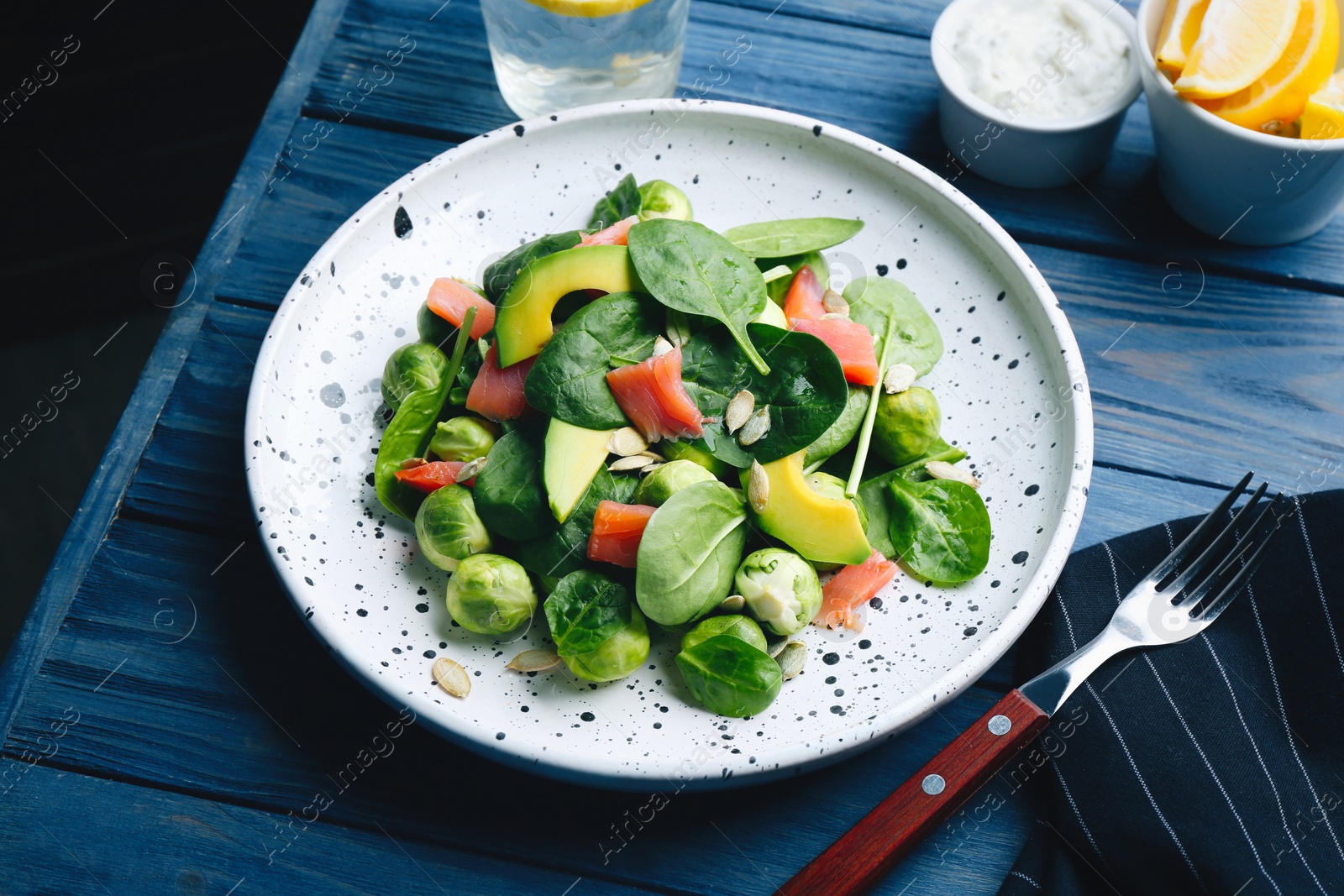 Image of Tasty salad with Brussels sprouts served on blue wooden table. Food photography  