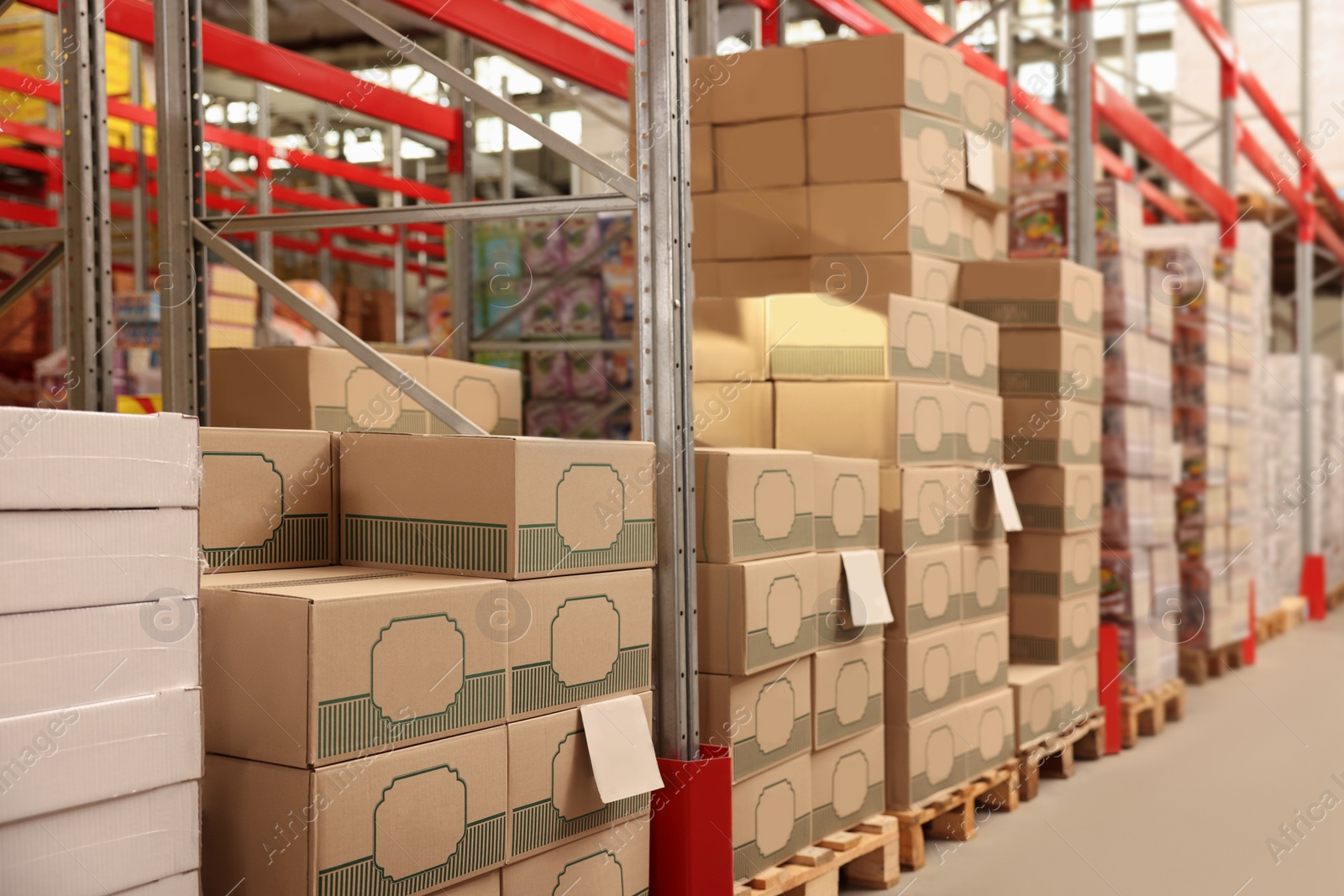 Photo of Warehouse with stacks of boxes on wooden pallets. Wholesaling