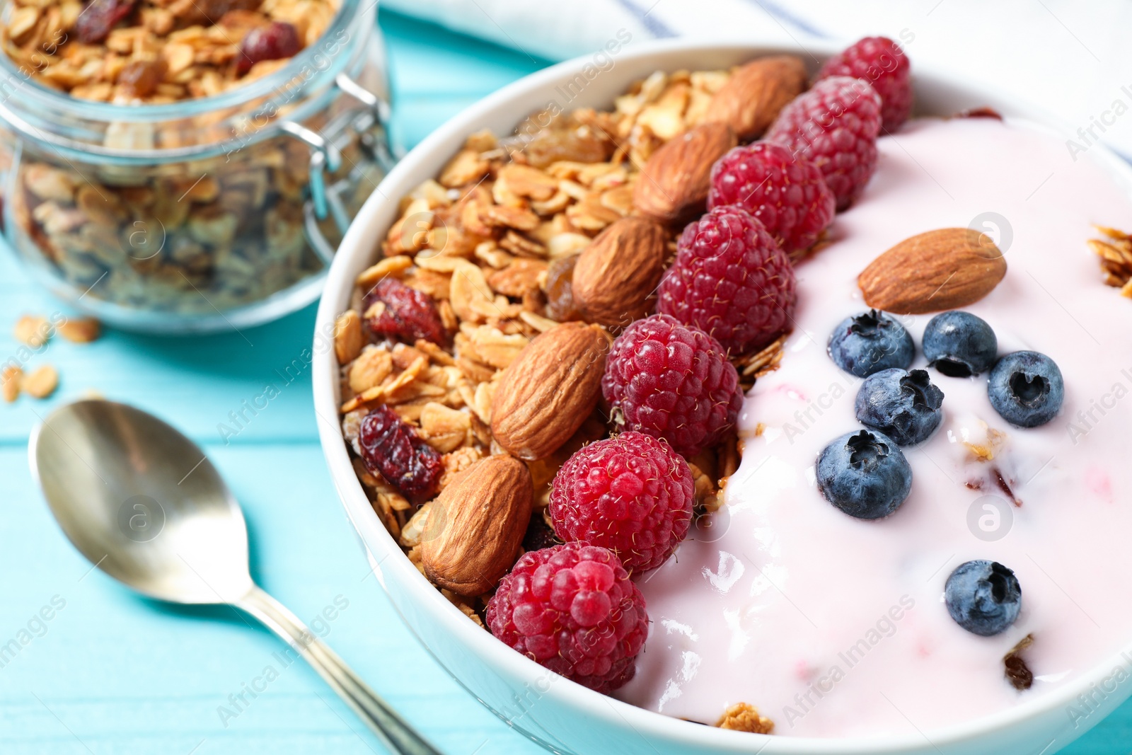 Photo of Tasty homemade granola served on blue wooden table, closeup. Healthy breakfast