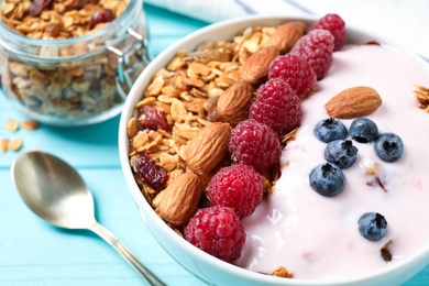 Photo of Tasty homemade granola served on blue wooden table, closeup. Healthy breakfast