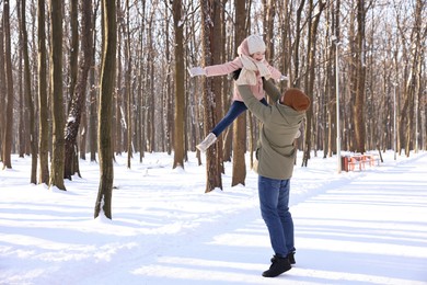 Family time. Father playing with his daughter in snowy forest. Space for text