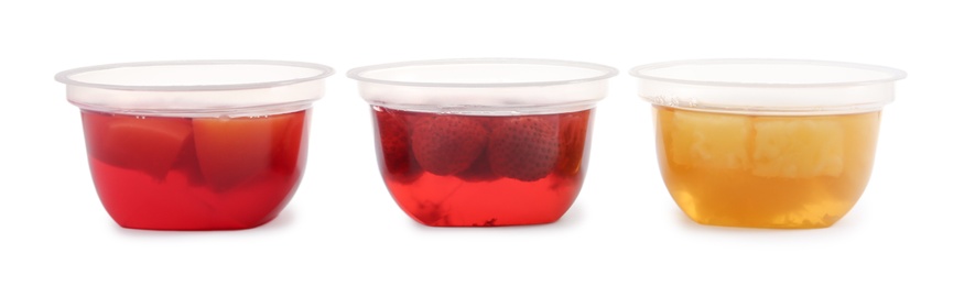 Tasty jelly desserts in plastic cups on white background