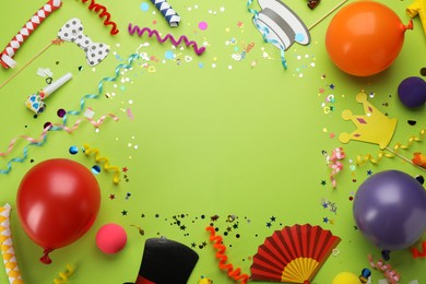 Photo of Frame made with carnival items on green background, flat lay. Space for text