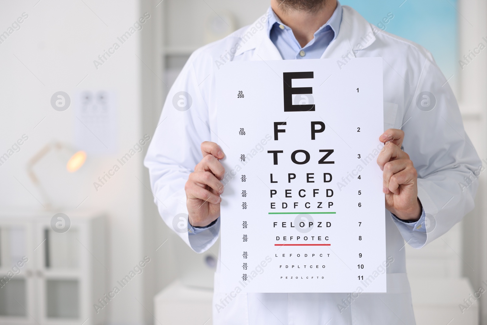 Photo of Ophthalmologist with vision test chart in clinic, closeup