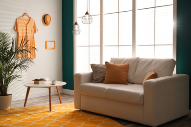 Image of Stylish room interior with comfortable sofa and orange carpet