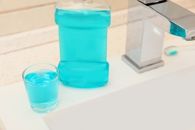 Photo of Mouthwash near tap on sink in bathroom. Teeth and oral care