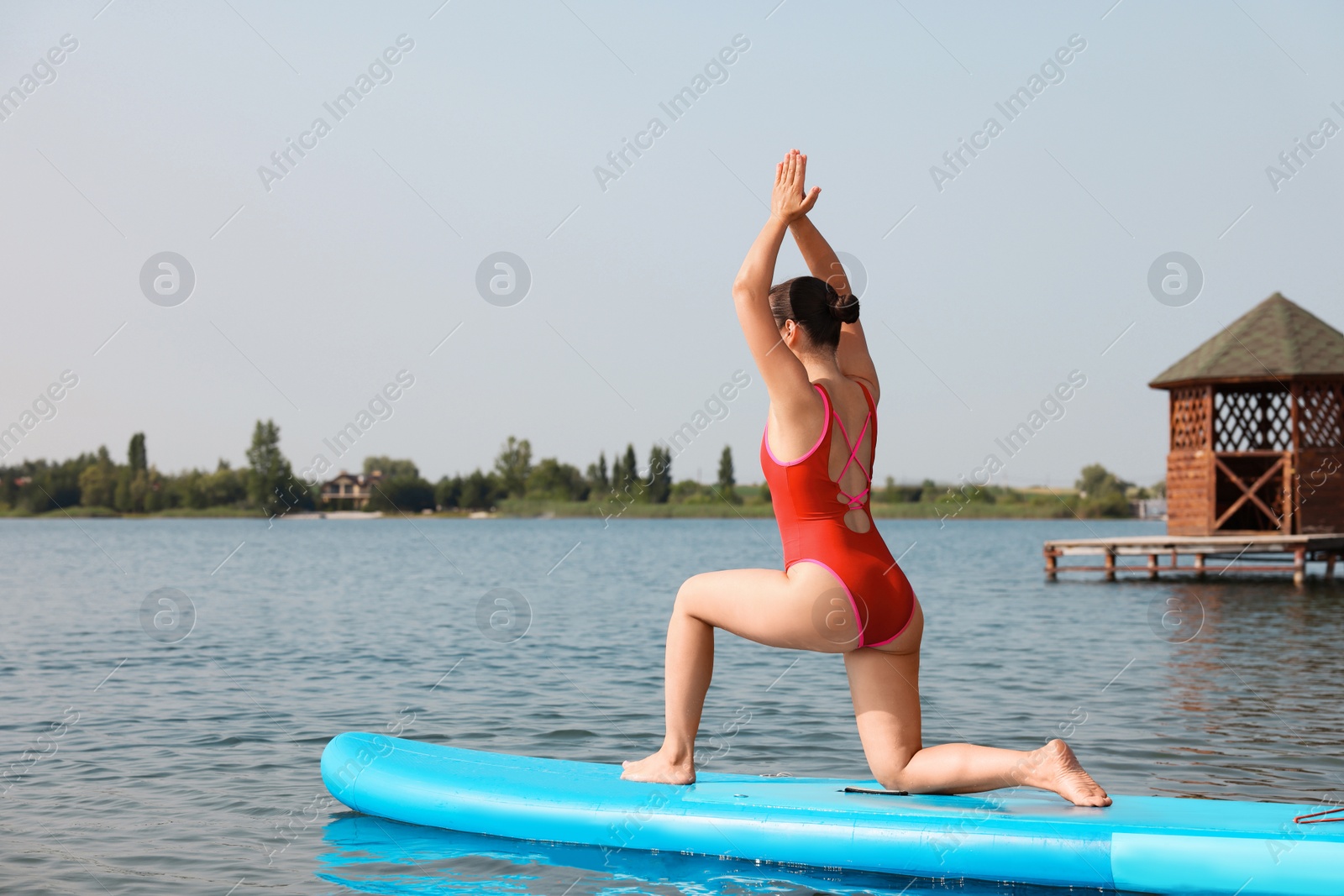 Photo of Woman practicing yoga on light blue SUP board on river, space for text