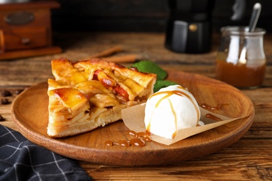 Photo of Slice of traditional apple pie with ice cream and mint on wooden table
