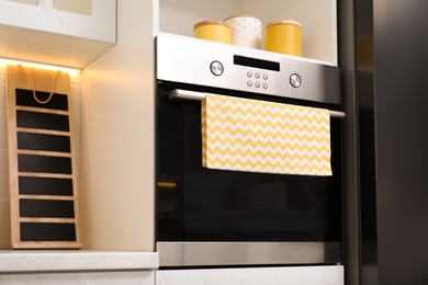 Photo of Clean towel on stove door in kitchen