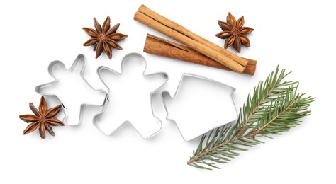 Photo of Different cookie cutters, cinnamon sticks, fir branch and anise stars on white background, top view