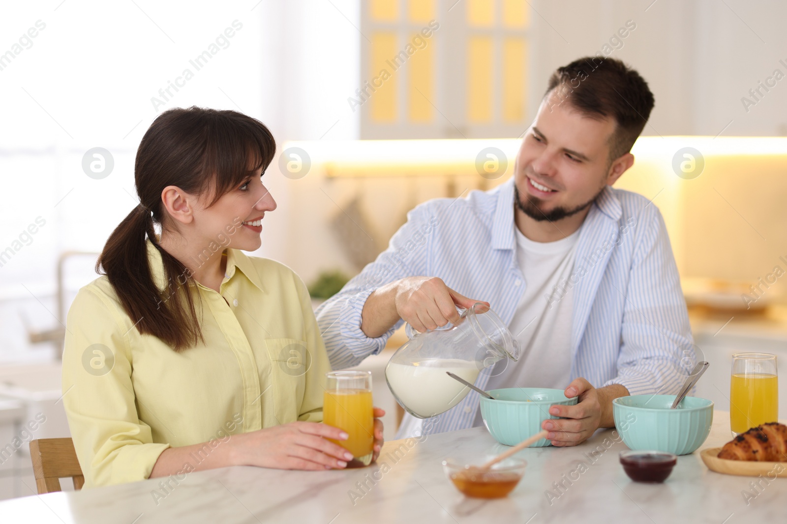 Photo of Happy couple having tasty breakfast at home