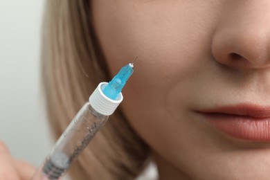 Cosmetologist with syringe on white background, closeup