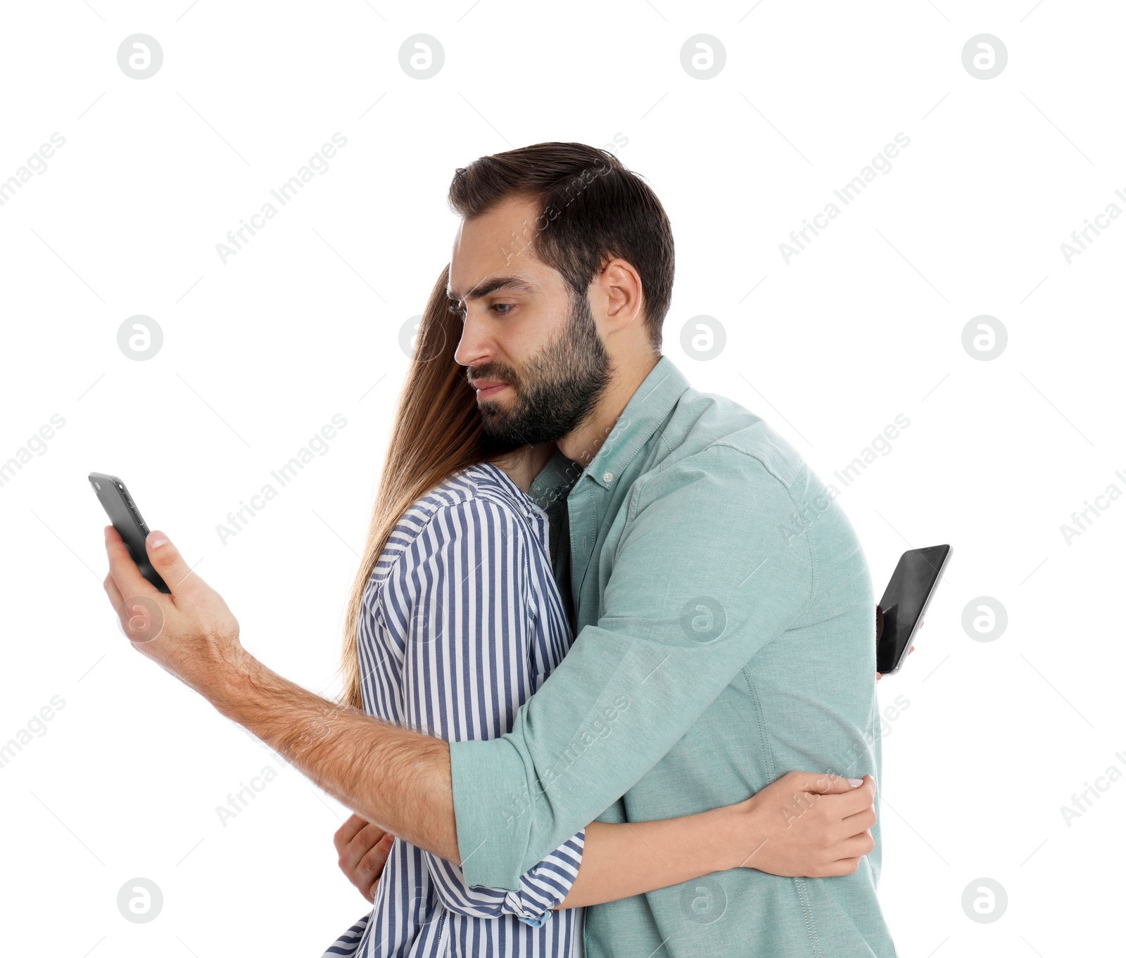 Photo of Couple addicted to smartphones hugging on white background. Relationship problems