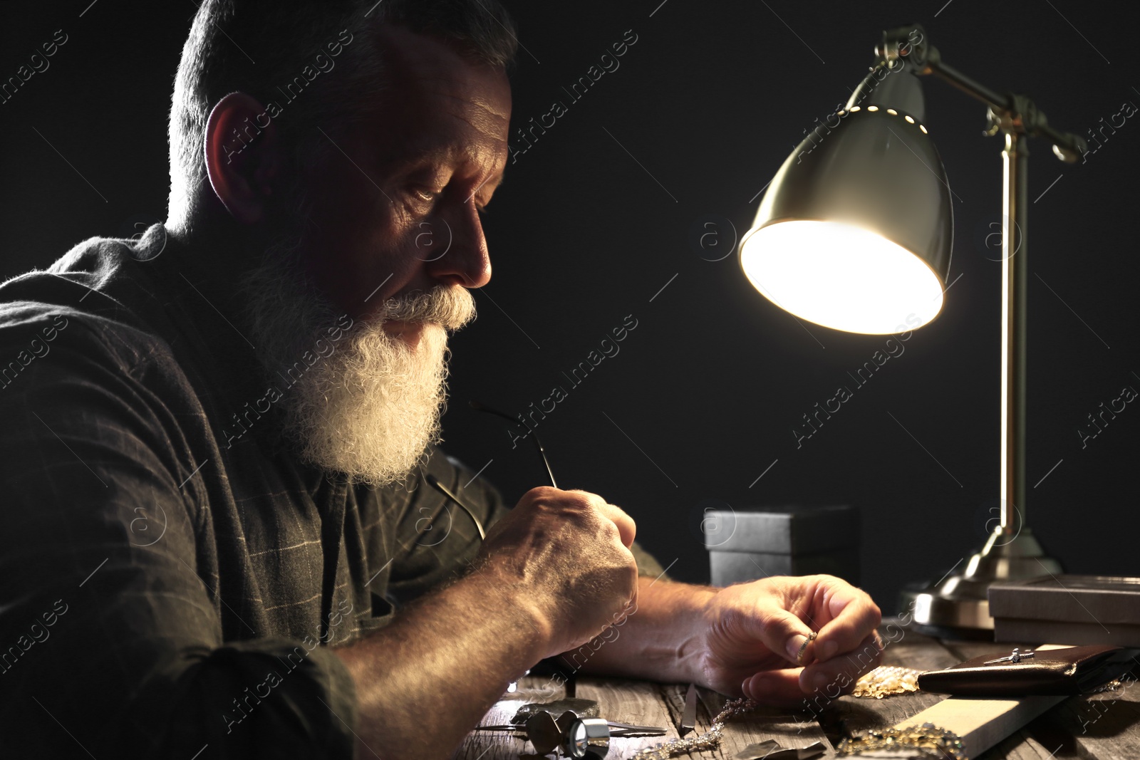 Photo of Male jeweler with precious gemstones in workshop