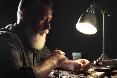 Photo of Male jeweler with precious gemstones in workshop