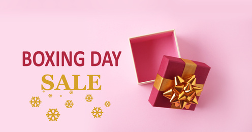 Boxing day sale. Top view of gift on pink background, banner design