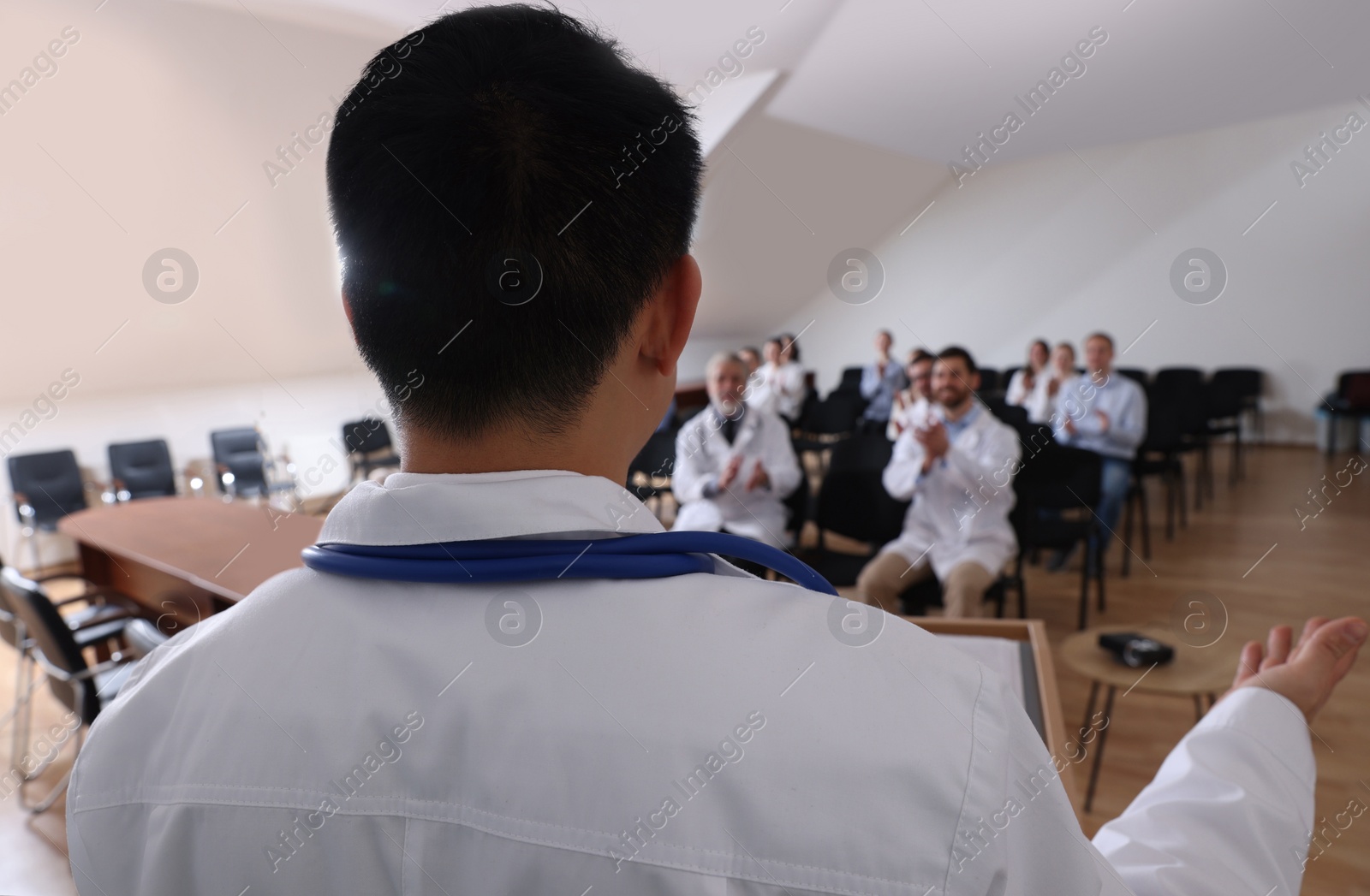 Photo of Doctor having discussion with audience in meeting room during medical conference, closeup