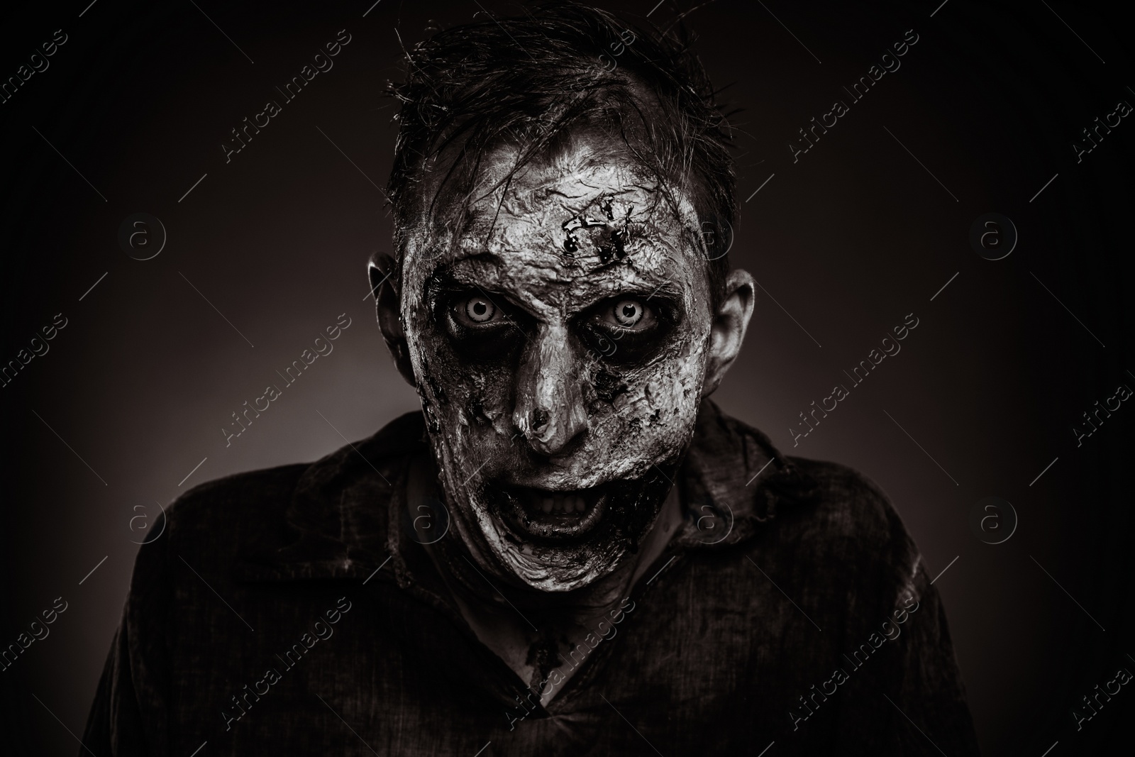 Photo of Scary zombie on dark background, black and white effect. Halloween monster