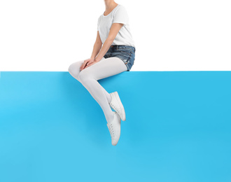 Photo of Woman wearing bright tights and stylish shoes sitting on color background, closeup