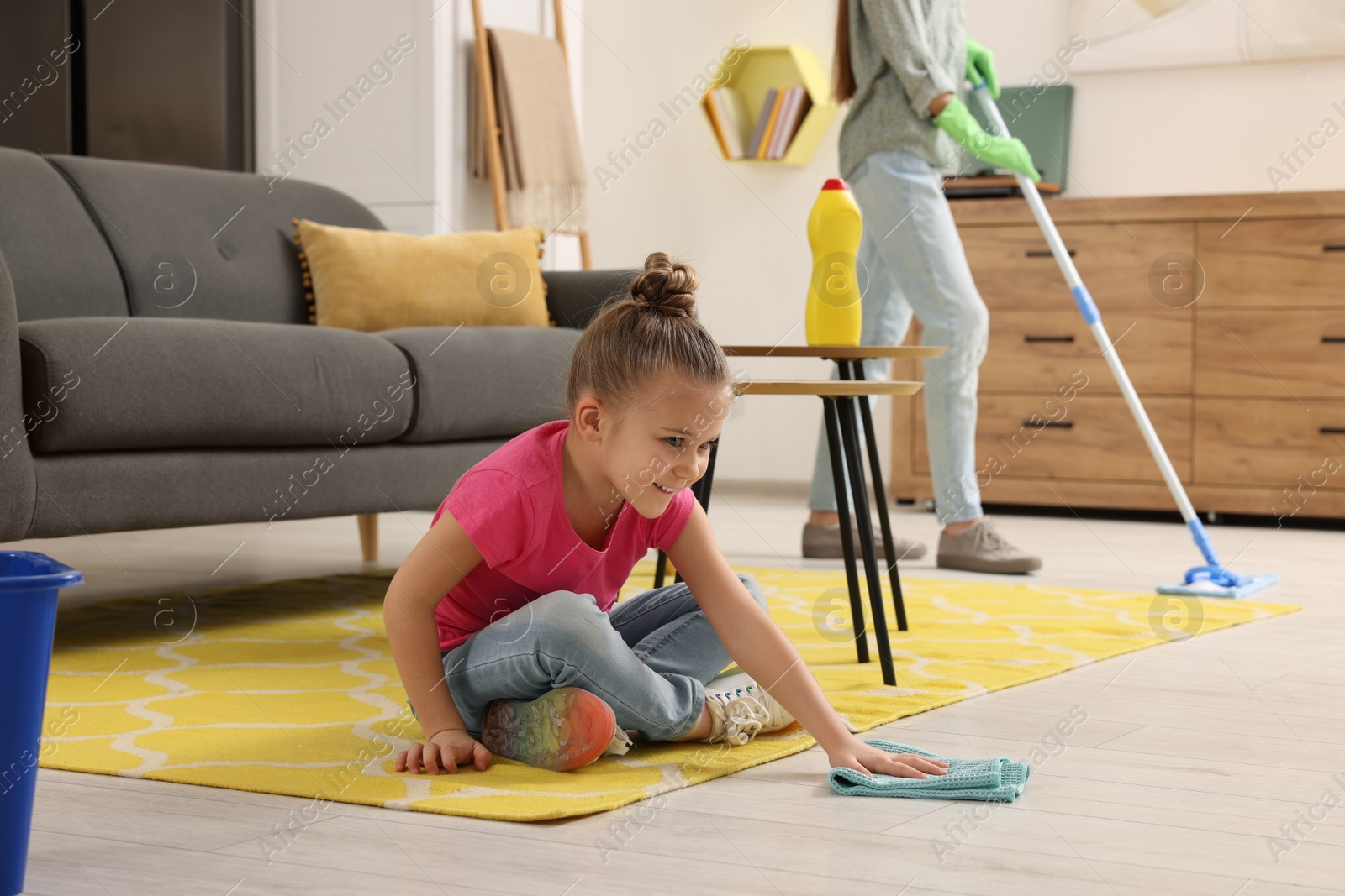 Photo of Spring cleaning. Mother and daughter tidying up living room together