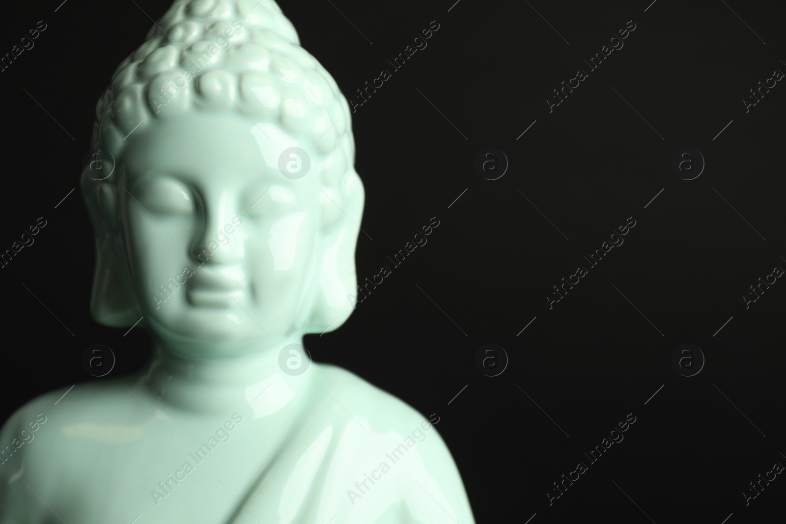 Photo of Beautiful ceramic Buddha sculpture on black background. Space for text
