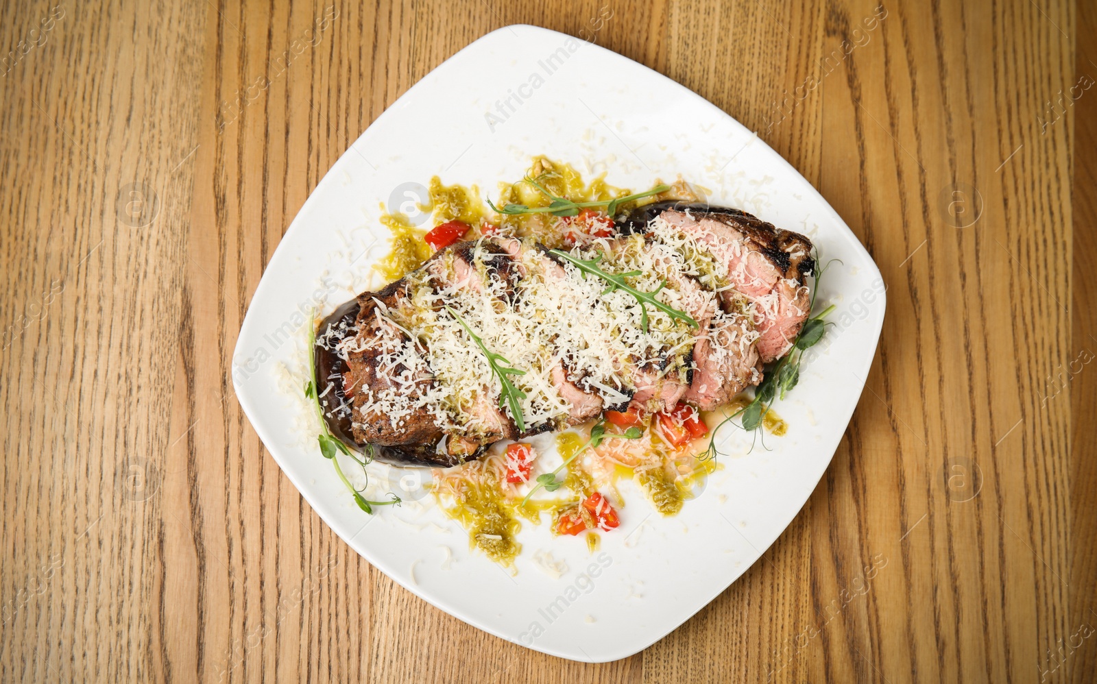 Photo of Delicious roasted meat served on wooden table, top view