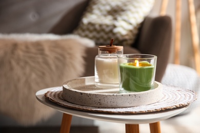 Photo of Aroma candles on small table indoors. Interior design