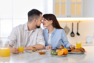 Photo of Happy couple spending time together during breakfast at home