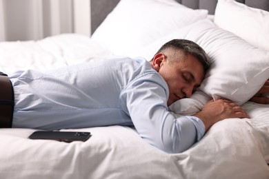 Photo of Businessman in office clothes sleeping on bed indoors