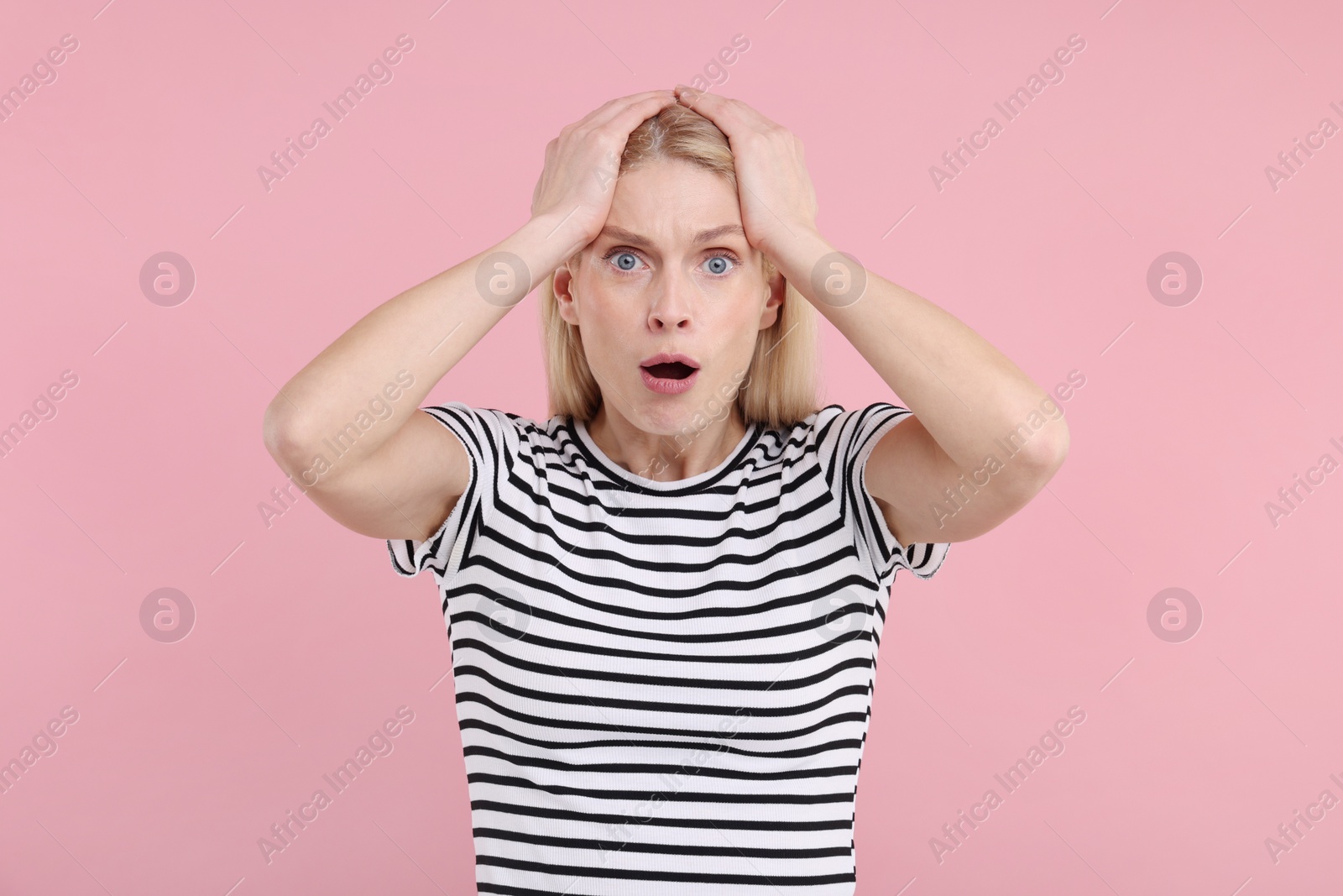 Photo of Portrait of surprised woman on pink background