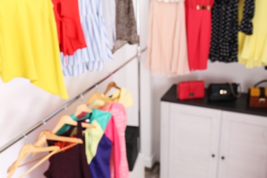 Blurred view of dressing room with different clothes and accessories