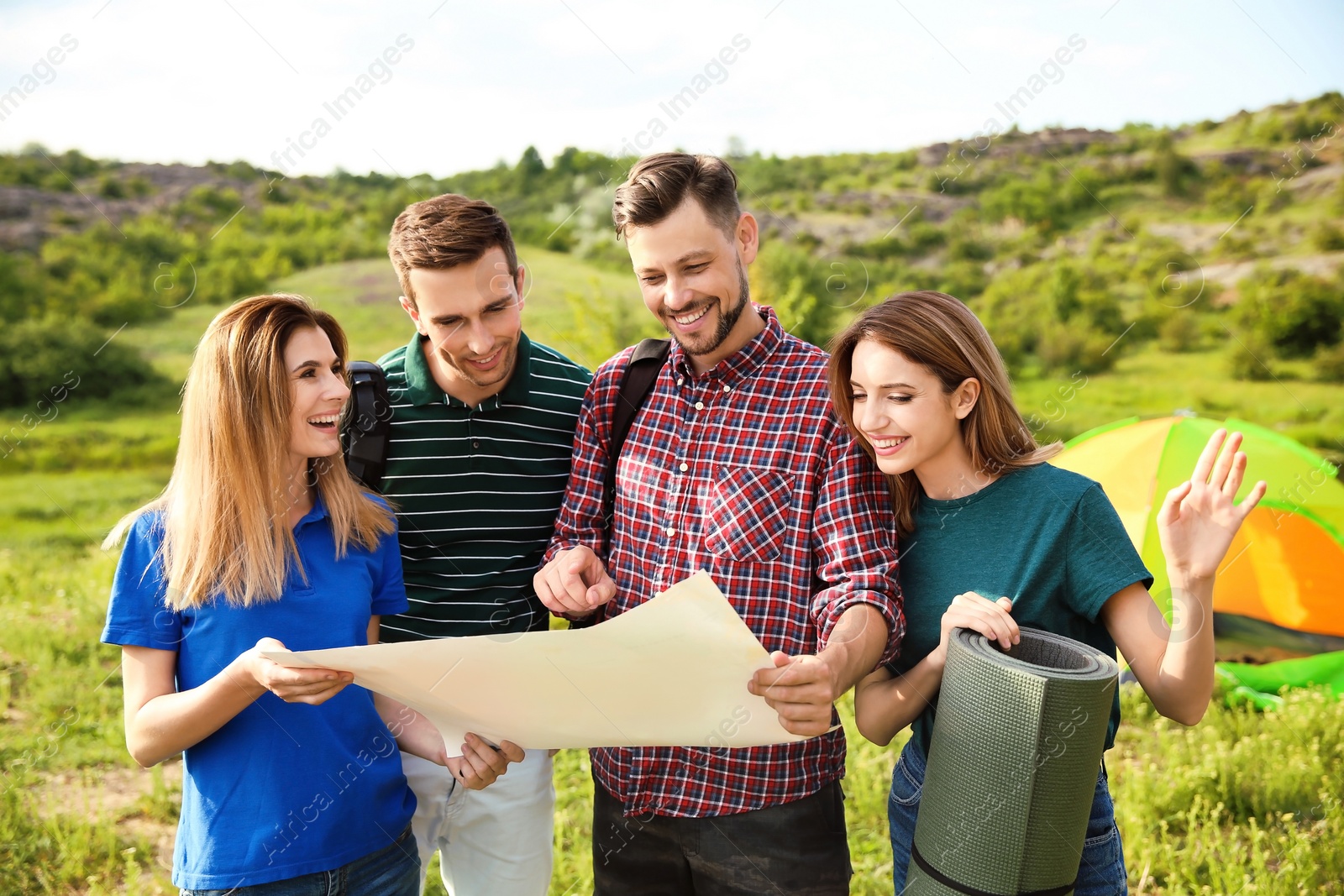 Photo of Young people exploring map in wilderness. Camping season