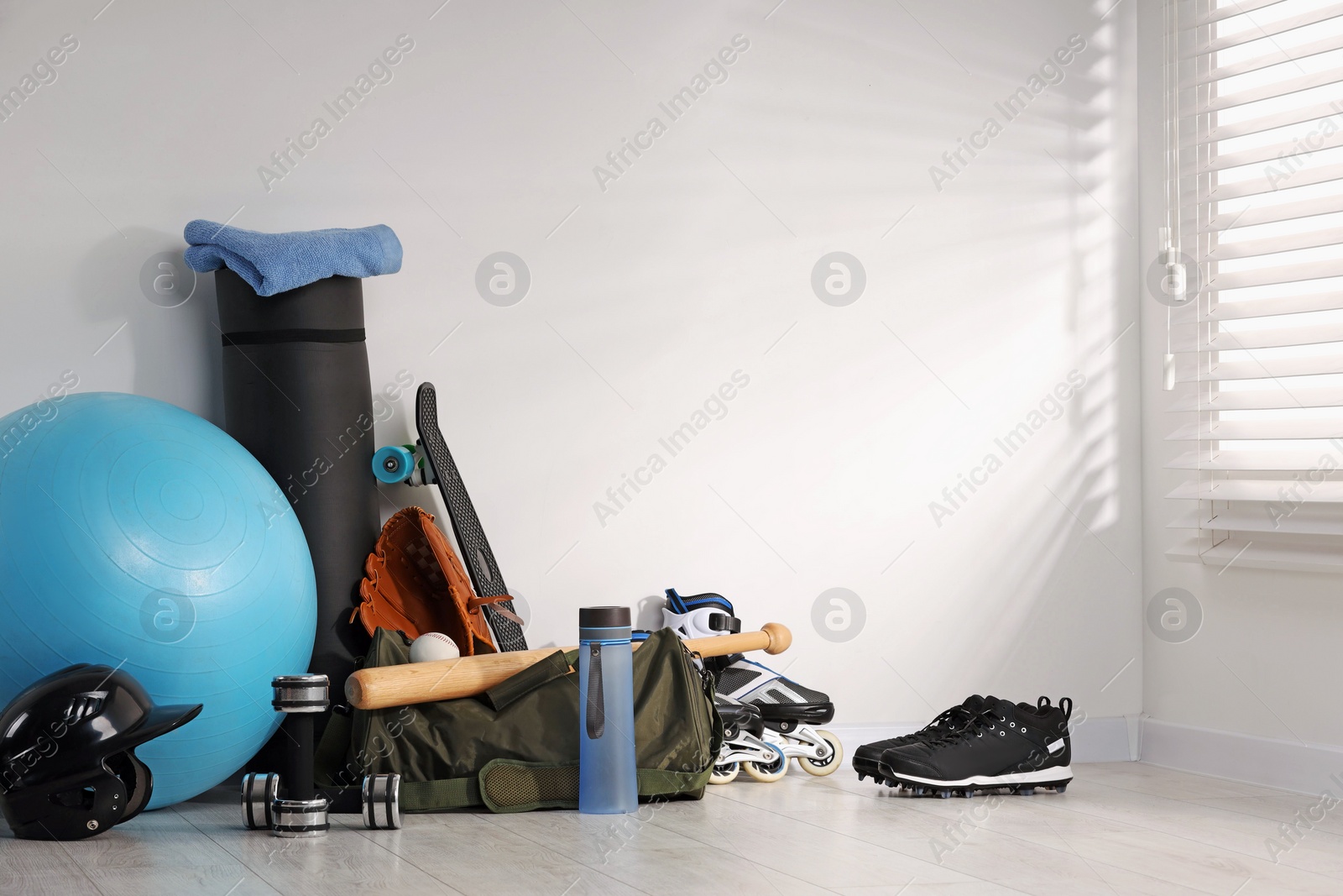 Photo of Many different sports equipment near wall indoors, space for text